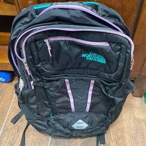 North face Recon backpack, black with green and purple accents.